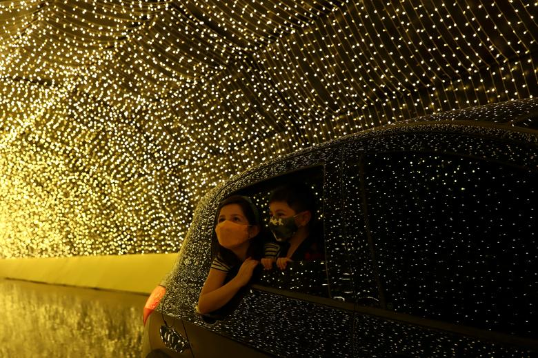  Hai đứa trẻ đeo khẩu trang ngắm nhìn ánh đèn lung linh từ bên trong ô tô khi đến tham quan Luminna Fest, lễ hội ánh sáng Giáng sinh ở Sao Paulo, Brazil, ngày 5/12. Nguồn: Reuters