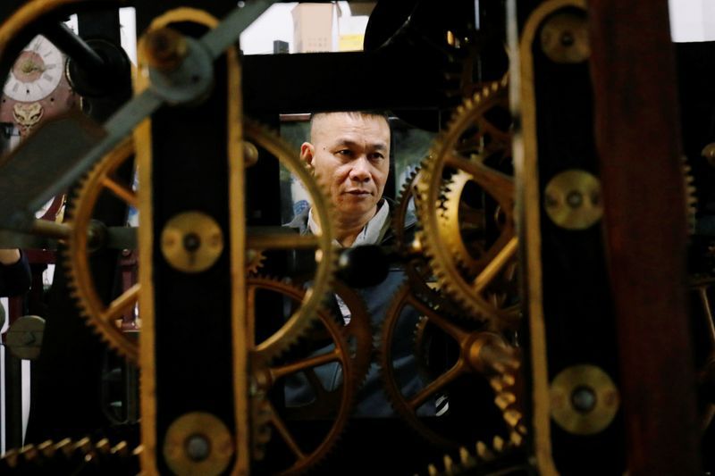 Không chỉ là người nghiên cứu và sưu tầm hàng trăm chiếc đồng hồ cổ, anh Thuộc còn là một người thợ sửa chuyên nghiệp. Ảnh: Reuters.
