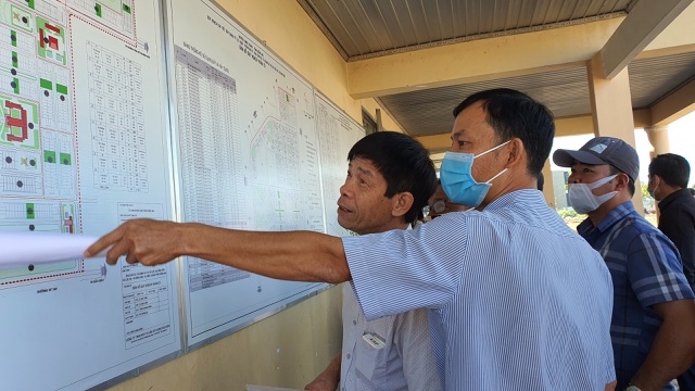 Người dân xem sơ đồ các vị trí đất trong khu tái định cư Lộc An - Bình Sơn. Ảnh: Dân Trí