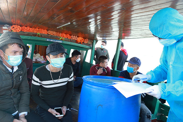 Lực lượng chức năng lập biên bản, xác minh nhóm công dân Việt Nam trốn cách ly y tế khi đi từ Macau, Trung Quốc về TP Hạ Long, Quảng Ninh. Ảnh: Tuổi Trẻ