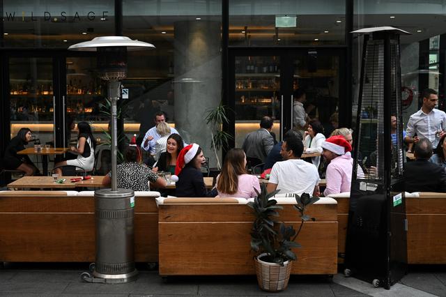 Người dân Úc đội nón Noel tại một quán bar và quán ăn ở trung tâm thành phố sau khi nới lỏng  các hạn chế do bệnh COVID-19 ở Sydney, Úc, ngày 10/12. Ảnh: Reuters