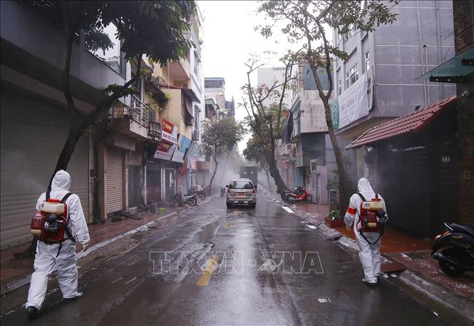 Lực lượng bộ đội hóa học triển khai phun hóa chất tiêu tẩy khu vực phố Châu Long, quận Ba Đình. Ảnh: TTXVN