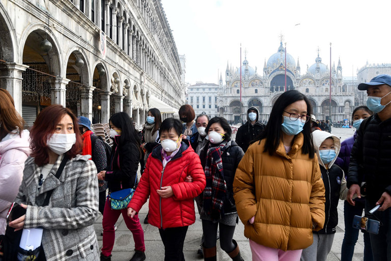 Du khách mang khẩu trang phòng ngừa virus Corona tham quan tại Venice. Ảnh: AFP.