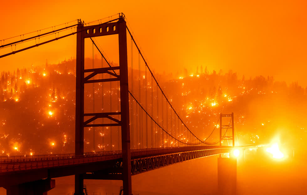 Oroville, Calif., Ngày 9/9/2020. Bầu trời chuyển sắc cam và vàng sẫm ở khu vực vịnh San Francisco do khói từ các đám cháy hoành hành khắp California, Mỹ và khu vực phía tây. Lửa đã đốt cháy một sườn đồi bên cạnh cầu Bidwell Bar. Trận cháy rừng đã xé nát 230.000 mẫu Anh trong khoảng thời gian 24 giờ. Ảnh: Noah Berger/Associated Press