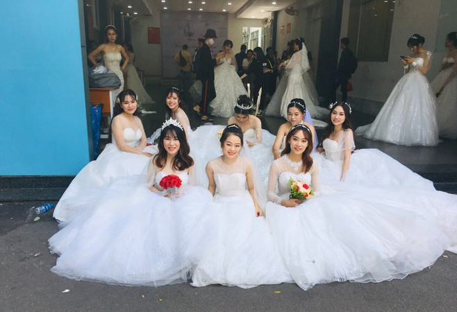 Hình ảnh dàn “cô dâu” diện váy cưới lộng lẫy xuất hiện trên sân trường được chia sẻ khiến dân mạng tò mò. Ảnh: Mạng xã hội