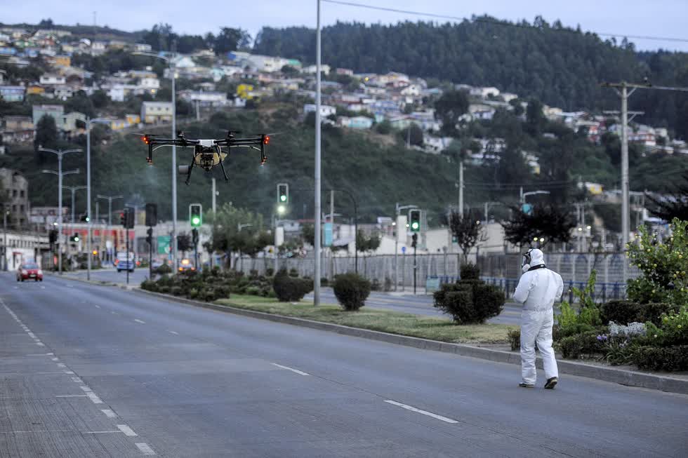 Một nhân viên cộng đồng địa phương sử dụng một máy bay không người lái chứa chất khử trùng ở Talcahuano, Chile. Ảnh: Reuters.