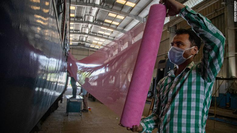   Các nhân viên đường sắt Ấn Độ lắp lưới chống muỗi ngoài toa xe lửa để làm khu cách ly cho cuộc chiến chống lại virus corona mới ở Gauhati vào ngày 29/3/2020.  