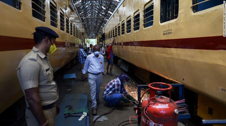 Các công nhân đeo khẩu trang thực hiện các công việc trên xe lửa sẽ được sử dụng làm nơi cách ly tạm thời để chuẩn bị cho bệnh nhân nhiễm COVID-19, tại một xưởng sản xuất xe khách ở Chennai vào ngày 30/3.