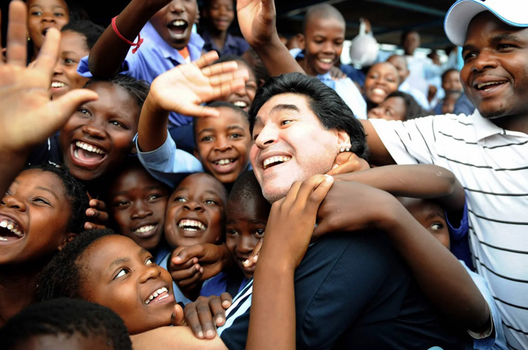 Những học sinh hân hoan khi Maradona đến thăm một trường học ở Nam Phi tháng 1/2010. Ở thời điểm này ông giữ vai trò huấn luyện viên đội tuyển Argentina. Ảnh: Getty Images