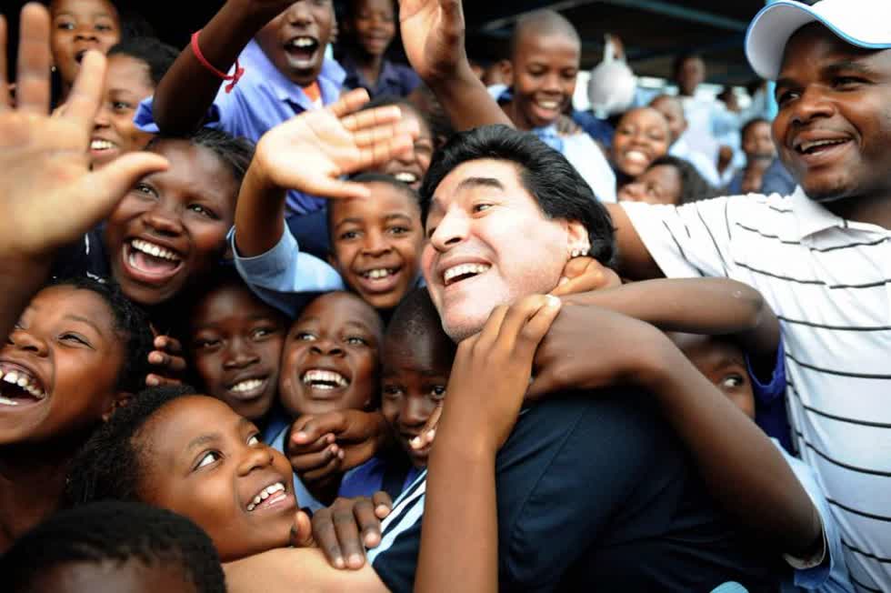 Thời còn làm huấn luyện viên trưởng cho đội tuyển Argentina, Maradona được các học sinh chào đón khi thăm ngôi trường Kgotlelelang ở Winterveldt, Nam Phi, tháng 1/2010. Ảnh: Getty Images