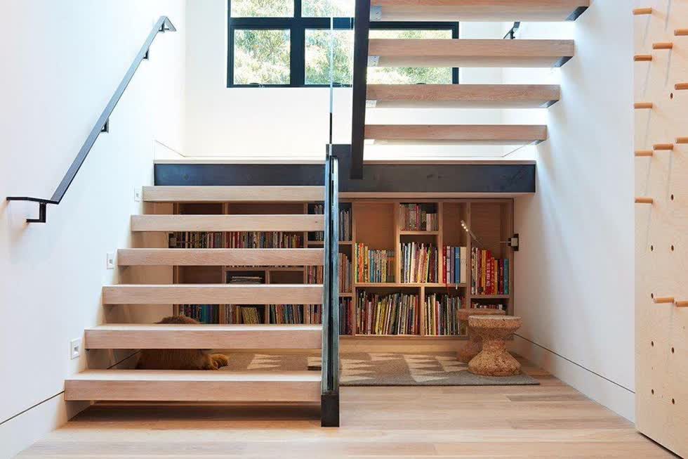Tủ sách ngay dưới gầm cầu thang giúp các thành viên có thể tiếp cận sách bất cứ lúc nào.