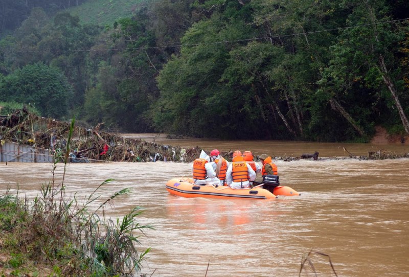 Lực lượng cứu hộ triển khai tìm kiếm nạn nhân mất tích tại khu vực cầu treo bị lũ cuốn. Ảnh: báo Nhân Dân