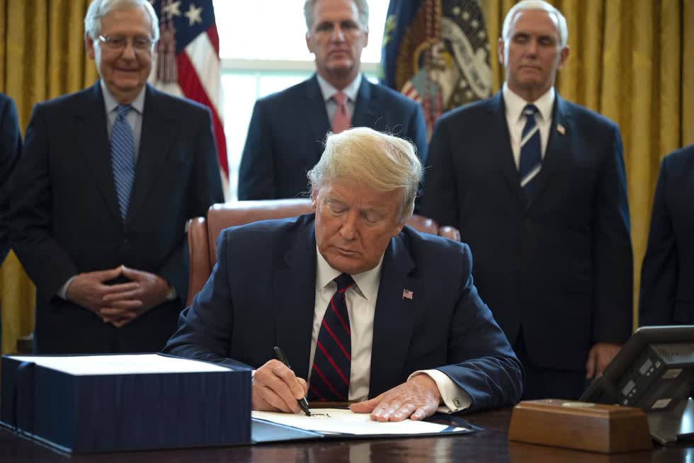 Tổng thống Mỹ Donad Trump ký phê chuẩn dự luật kích thích kinh tế trị giá 2000 tỷ USD tạiNhà Trắng ngày 27/3/2020. Ảnh: TTXVN.