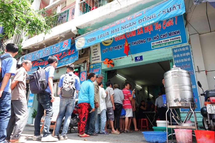 Cảnh xếp hàng dài vào giờ ăn trưa tại quán cơm Nụ Cười, hệ thống quán cơm xã hội nổi tiếng Sài Gòn.