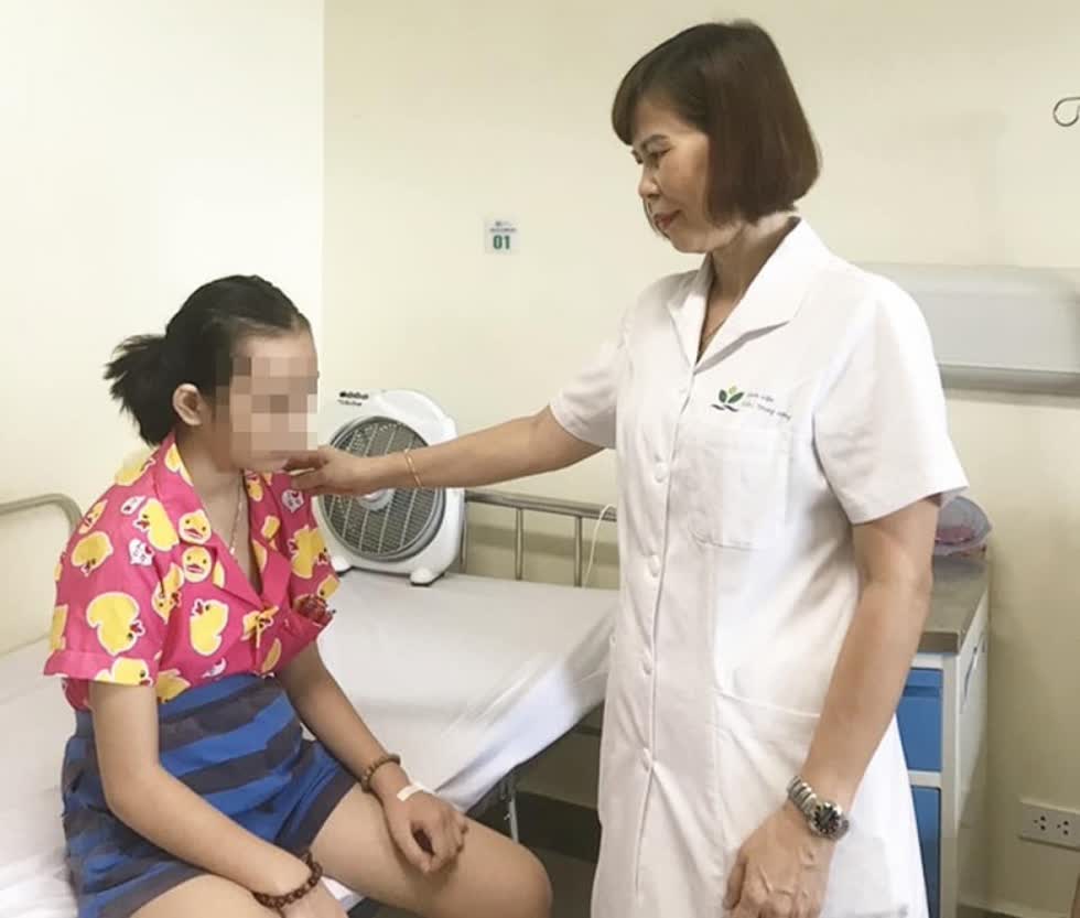 TS.BS Đỗ Minh Loan thăm khám cho một học sinh tại Bệnh viện Nhi trung ương. Ảnh: BVCC