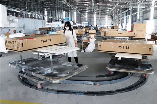 Đóng gói và kiểm tra lô hàng đồ gỗ xuất khẩu sang thị trường Mỹ tại Công ty Triệu Phú Lộc (Bình Dương). Ảnh: TTXVN