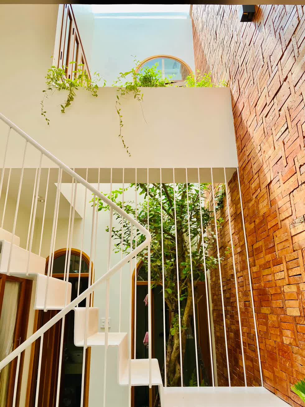 Cầu thang bằng thép màu trắng nhẹ nhàng, tinh tế dẫn lên tầng 2 của ngôi nhà.