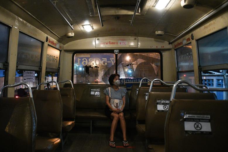   Một người phụ nữ đeo khẩu trang bảo vệ ngồi trên một chiếc ghế nhằm giãn cách xã hội khi cô ấy đi xe buýt ở Bangkok, Thái Lan, ngày 27/3.  