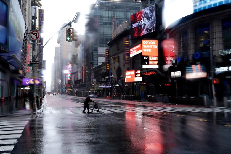   Một người có người đi bộ băng qua đường 42 tại Quảng trường Thời đại vắng vẻ ở Manhattan, thành phố New York.  