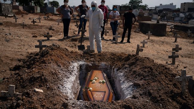 Một nhân viên nghĩa trang và người thân đến chôn cất cô  Edenir Rezende Bessa, người bị nghi là đã chết do COVID-19, tại Rio de Janeiro, Brazil, hôm 22/4. Ảnh: AP