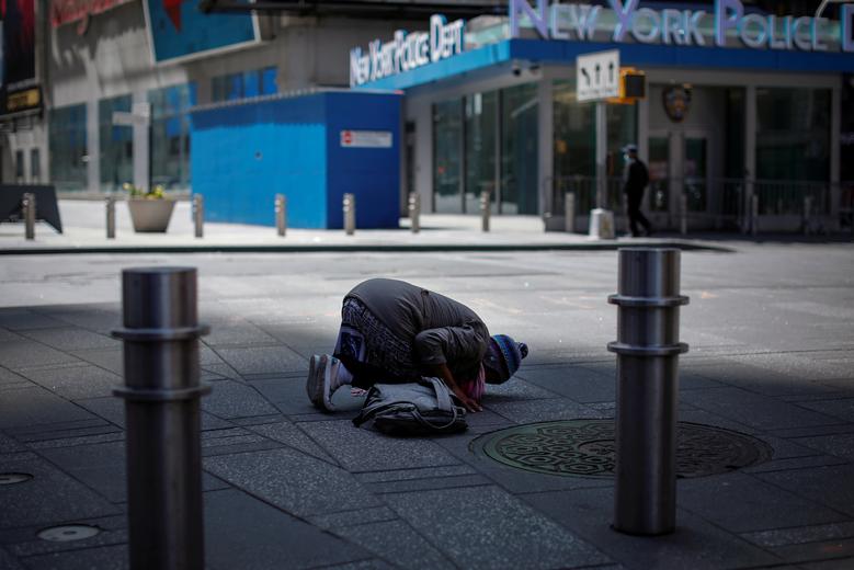   Một phụ nữ Hồi giáo quỳ gối cầu nguyện giữa trưa tại Quảng trường Thời đại gần như trống rỗng ở Manhattan, thành phố New York.  