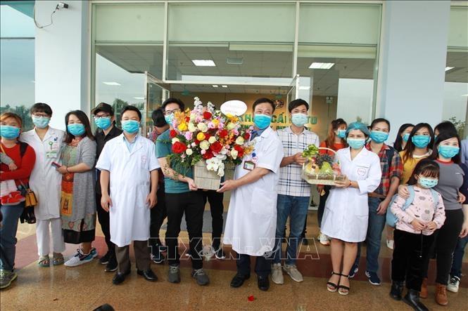 Cán bộ, bác sỹ Bệnh viện Nhiệt đới Trung ương tặng hoa chúc mừng 30 người trở về từ Vũ Hán (Trung Quốc) hoàn thành thời gian cách ly, ngày 2/3/2020. (Ảnh: TTXVN)