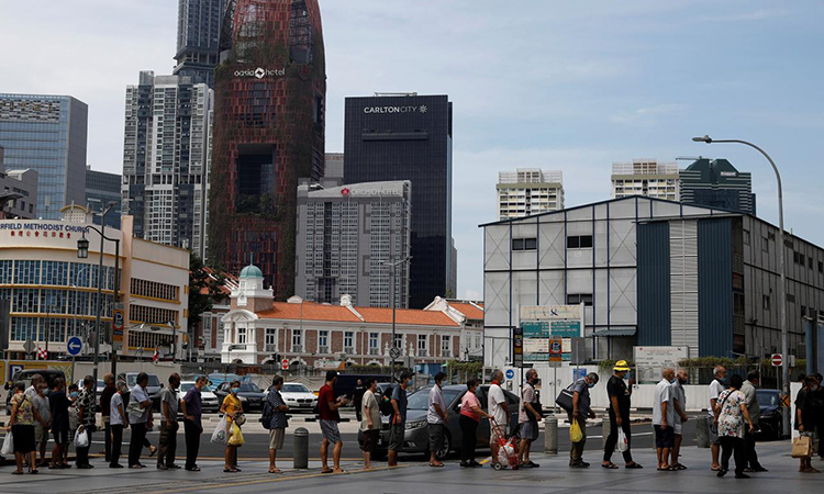   Người dân xếp hàng nhận thực phẩm miễn phí tại khu China Town, Singapore, hôm 17/4. Ảnh: Reuters.  
