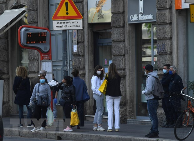 Người dân di chuyển xuống phố ở Milan, Italy ngày 18/4/2020 trong bối cảnh dịch COVID-19 đang hoành hành. (Ảnh: TTXVN)