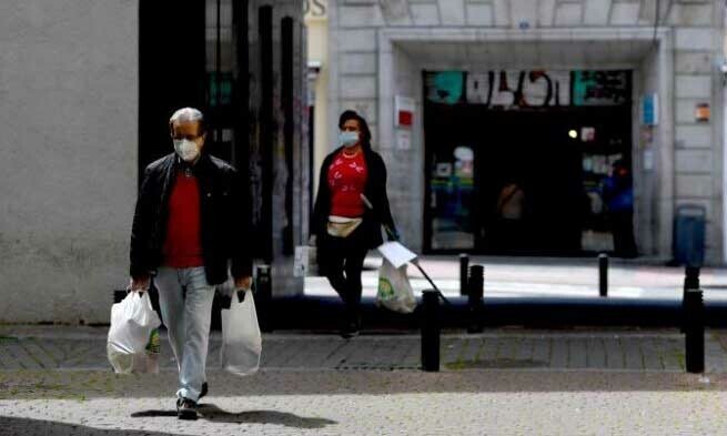   Người dân xách đồ mua từ tiệm tạp hóa tại thủ đô Madrid, Tây Ban Nha, hôm 20/4. Ảnh: AFP.  