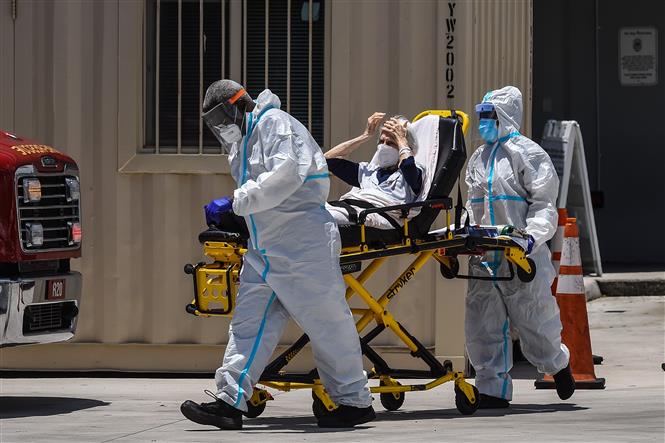 Nhân viên y tế chuyển bệnh nhân COVID-19 tới bệnh viện ở Coral Gables, gần Miami, Mỹ. Ảnh: AFP