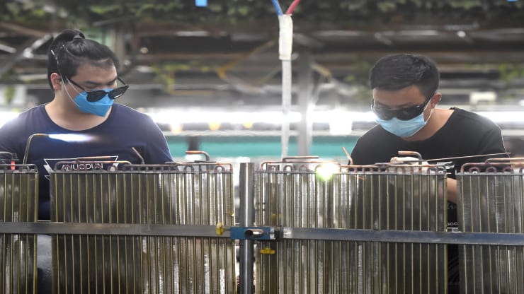   Công nhân lắp ráp máy điều hòa không khí tại một nhà máy Midea ở Vũ Hán vào ngày 26/3. Ảnh: Getty.  