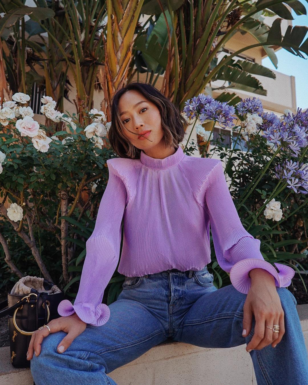 Aimee Song mặc áo sơ mi voan màu tím lilac và quần jeans
