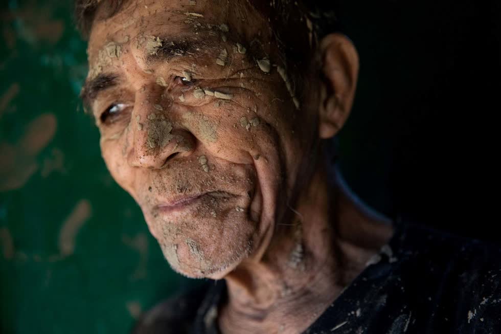 Người đàn ông tạm nghỉ việc dọn dẹp ngôi nhà của mình, nơi dính đầy bùn ở San Mateo vào ngày 13/11. Ảnh: Reuters