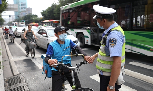   Một cảnh sát tuyên truyền cho người lái xe điện không đội mũ bảo hiểm vào hôm 21/5 tại tỉnh Quảng Đông, Trung Quốc.  