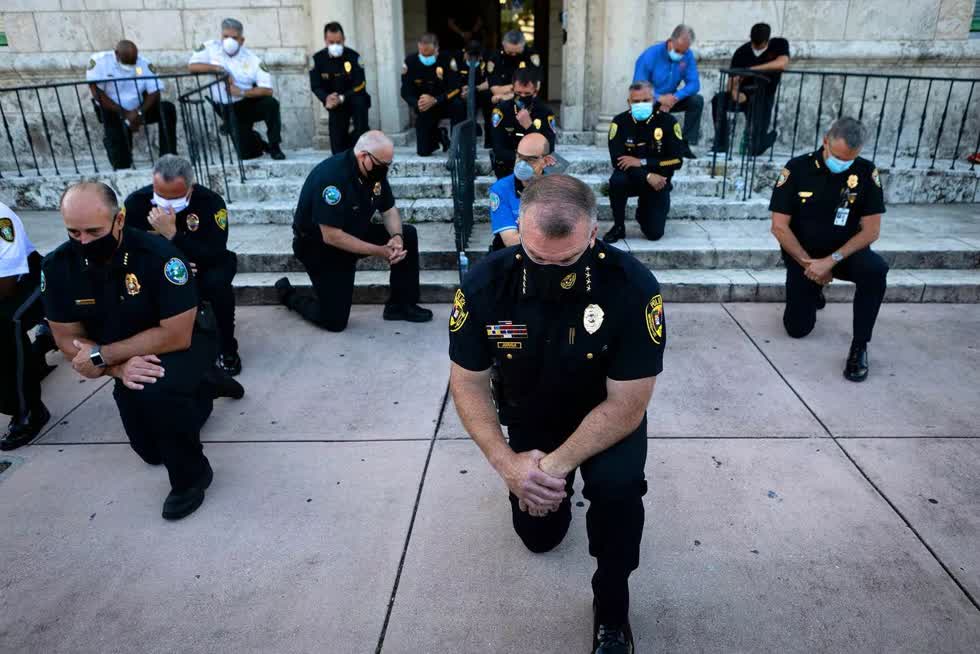 Cảnh sát quỳ gối tại TP Coral Gables, bang Florida (Mỹ) ngày 30/5, thể hiện thái độ phản đối trong vụ một đồng nghiệp da trắng của mình dùng đầu gối kẹp cổ một người đàn ông da đen tên George Floyd đến chết. Ảnh: Getty Images 