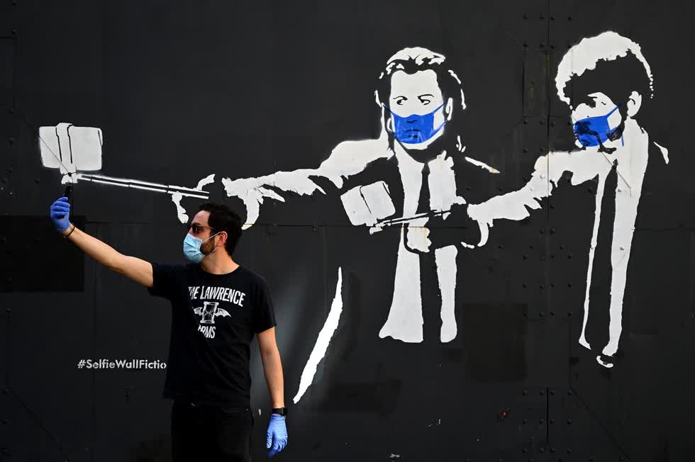 Hình vẽ graffiti của các diễn viên John Travolta và Samuel L. Jackson Trong các vai diễn của họ trong phim Pulp Fiction, đeo khẩu trang, Madrid, ngày 3/5.