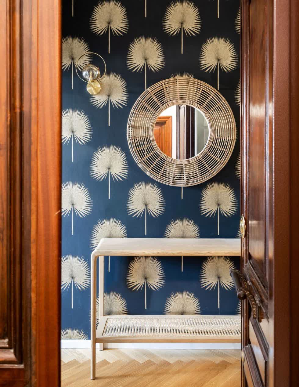 Một phần tường ở hành lang được dán giấy hoa văn tạo điểm nhấn, thêm vào đó là chiếc gương treo tường cách điệu, lạ mắt .