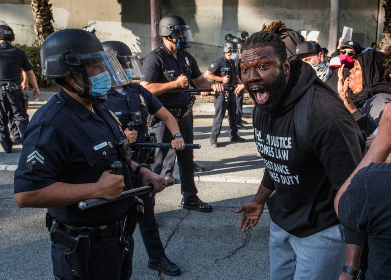 Một người biểu tình đối đầu với cảnh sát ở Los Angeles, Mỹ. Ảnh: AFP