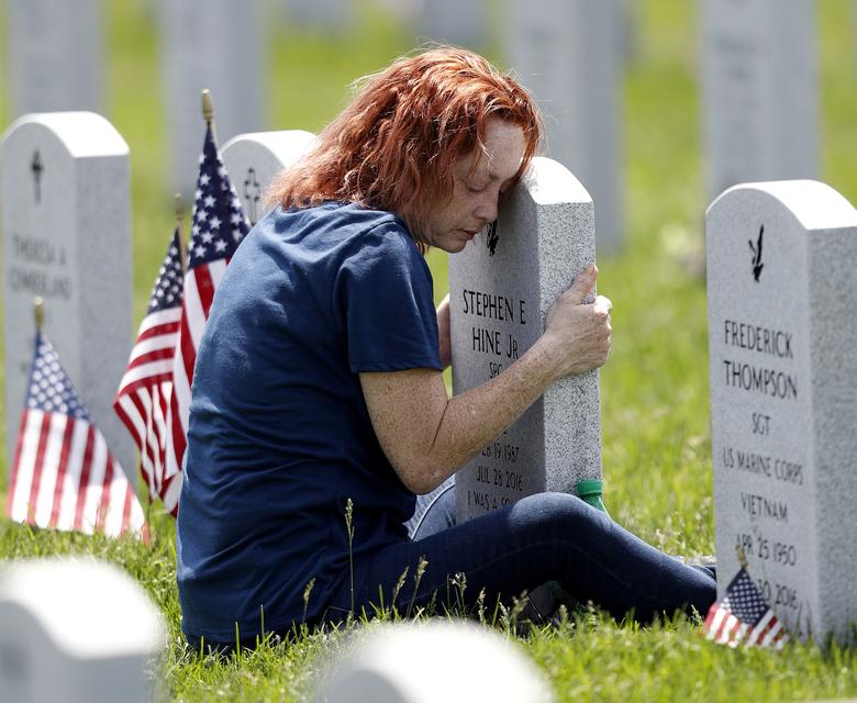   Maria Velez ở Orlando, Florida, ôm bia mộ của con trai Stephen tại Nghĩa trang Quốc gia Dự trữ Tây Ohio vào Ngày Tưởng niệm ở Seville, Ohio. Ảnh: REUTERS   