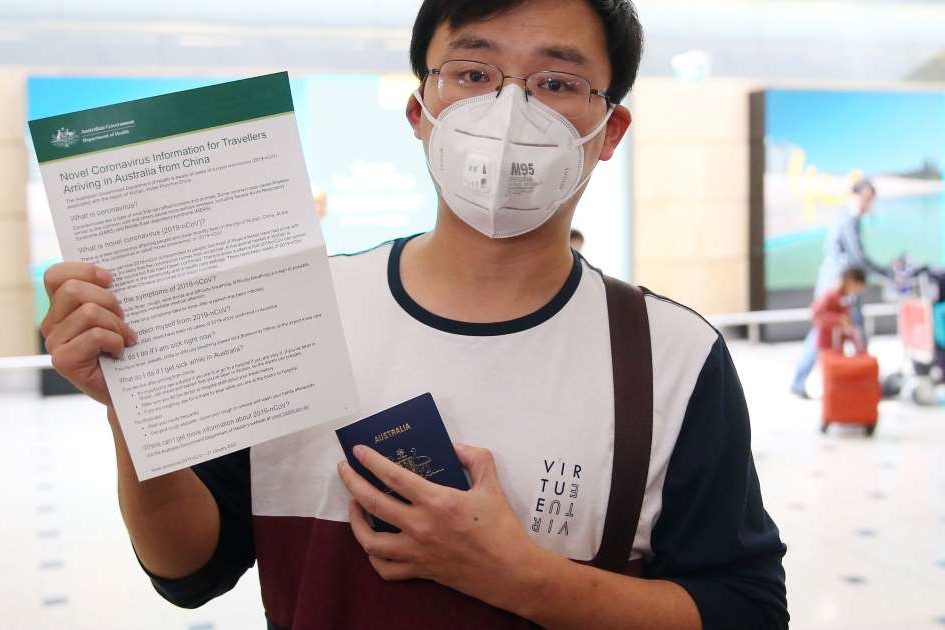 Du học sinh Trung Quốc cầm trên tay văn bản do chính phủ Australia phát hành liên quan đến các biện pháp ứng phó virus corona. Ảnh: AAP  