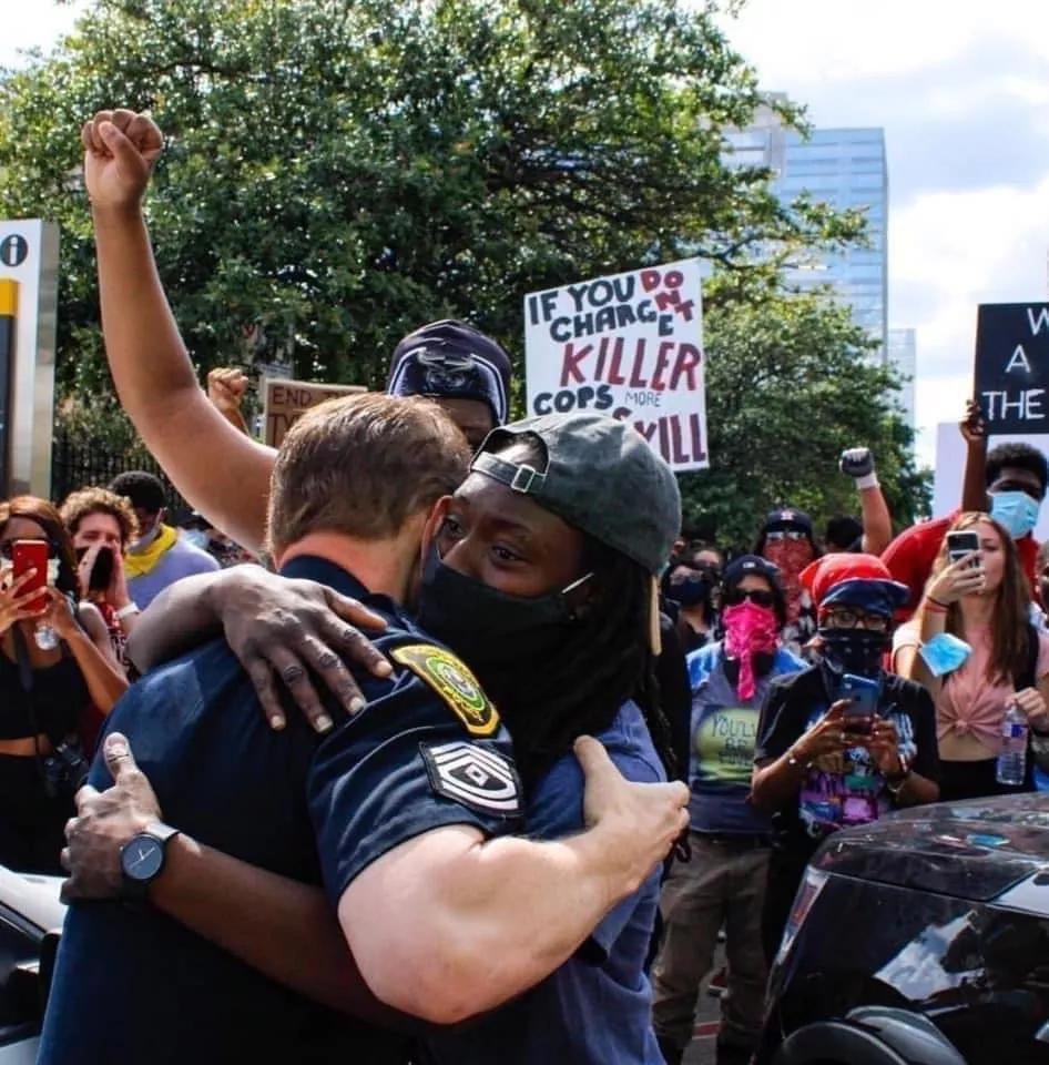 Một người biểu tình và một sĩ quan cảnh sát ôm nhau ở Miami. Họ cùng cầu nguyện cho người đã khuất và cầu mong nước Mỹ được hòa bình. Nguồn: ABC News