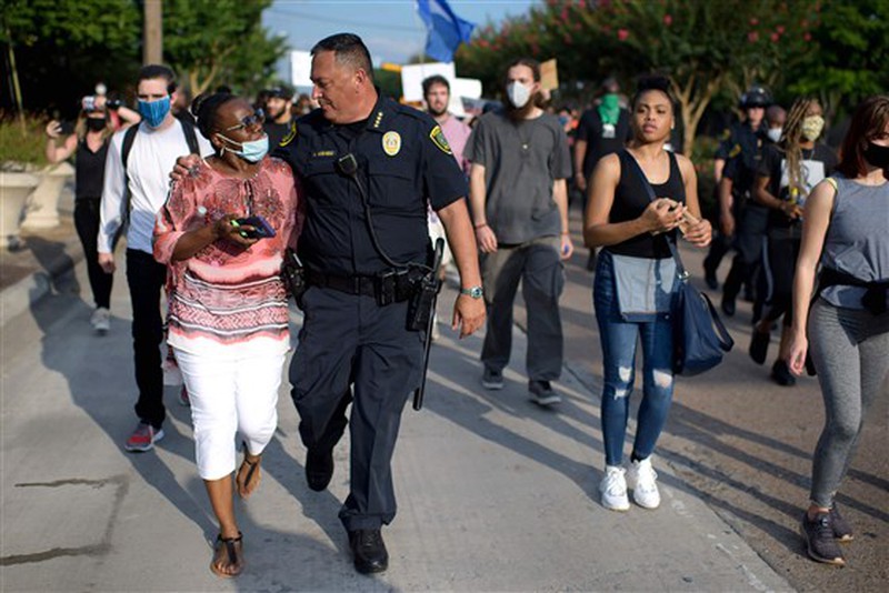 Ông Art Acevedo, cảnh sát trưởng Houston, bang Texas (Mỹ) khoác vai một phụ nữ trong một cuộc tuần hành tìm công lý cho người đàn ông da màu George Floyd, ngày 30/5. Ảnh: Getty Images 