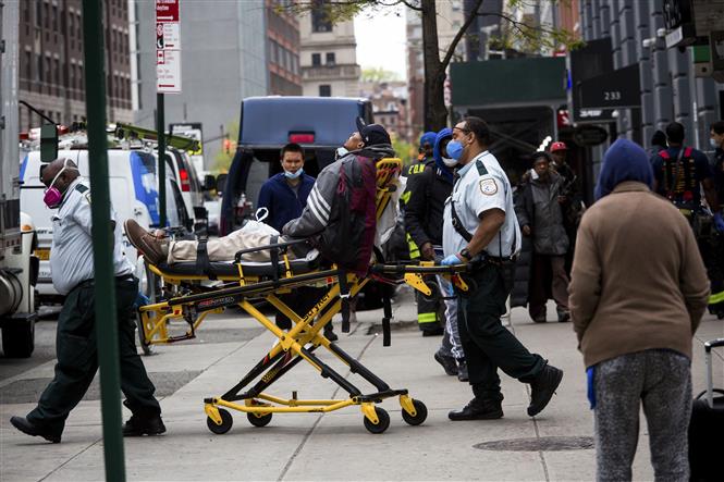   Nhân viên y tế chuyển bệnh nhân COVID-19 lên xe cứu thương tại New York, Mỹ ngày 8/5/2020. Ảnh: TTXVN.