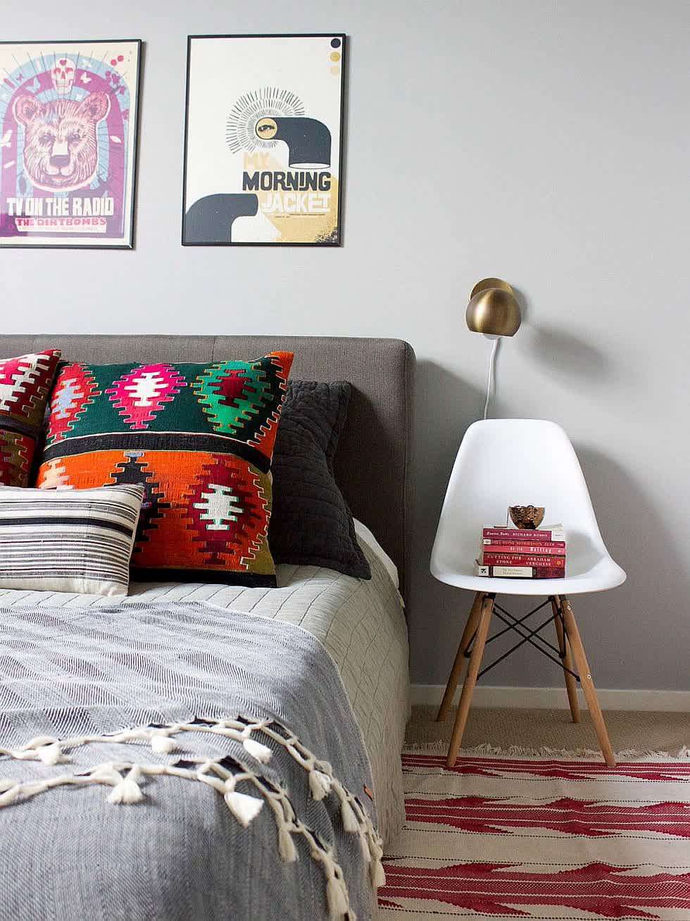 Sự cân bằng đáng yêu của màu sắc trong phòng ngủ được nhấn mạnh bằng cách sử dụng ghế đầu giường màu trắng.