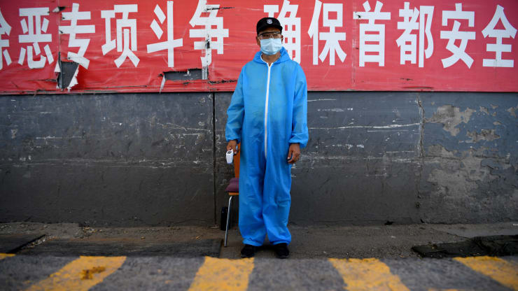  Một nhân viên bảo vệ đeo khẩu trang bảo hộ đứng ở trạm kiểm soát tại chợ đầu mối Tân Phát Địa ở Bắc Kinh vào ngày 14/6. Ảnh: AFP.  