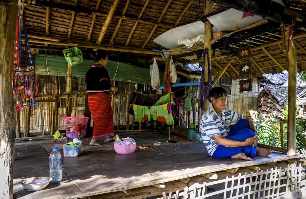 Hình ảnh một gia đình ngồi buồn trước ngôi nhà của họ tại bộ lạc Baan Tong Luang. Ảnh: AFP.