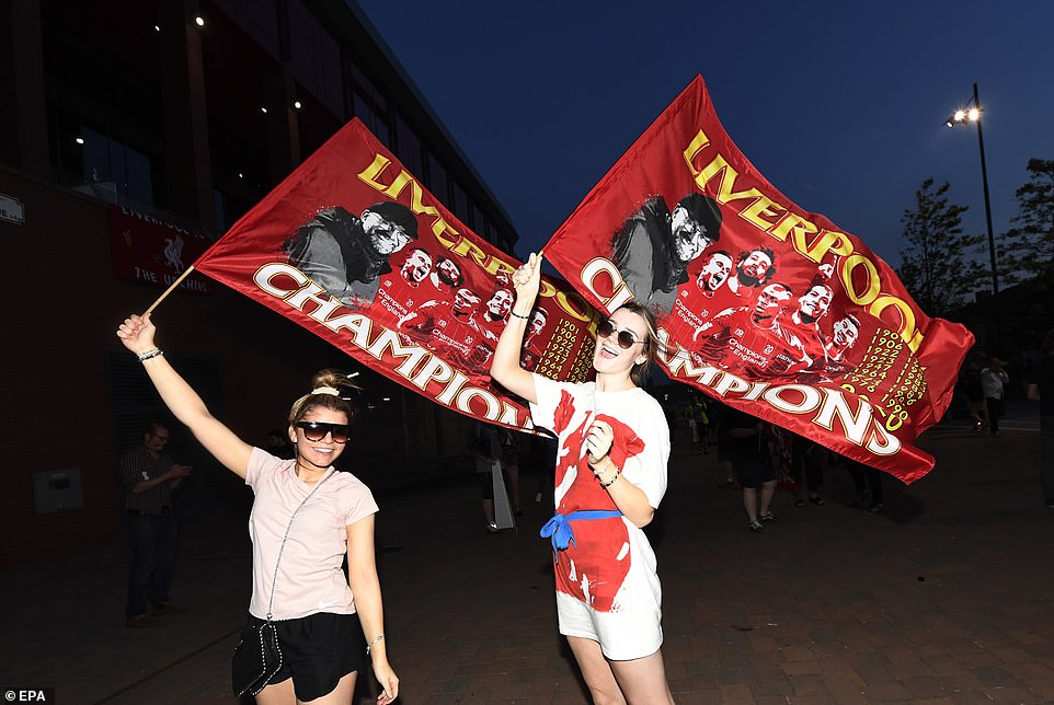 Chiến thắng của The Kop sau 30 năm làm các cổ động viên vô cùng phấn khích. Hai nữ CĐV đang giương cờ có hình ảnh của các thành viên Liverpool.                Các CĐV không đeo khẩu trang bất chấp nguy cơ nhiễm Covid-19.        