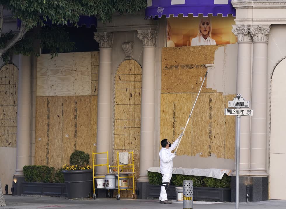 Một người lao động sơn tấm ván che cửa sổ ván tại khách sạn Beverly Wilshire, ở Beverly Hills, California. Ảnh AP