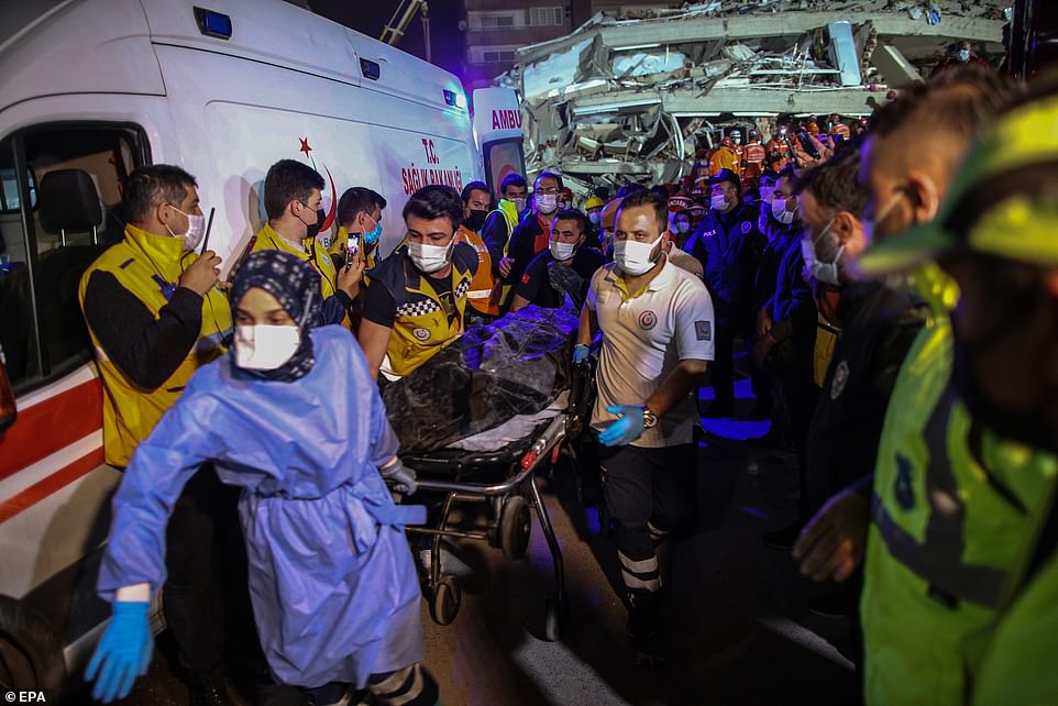 Nhân viên cứu hộ và y tế khiêng một người dân thiệt mạng từ một tòa nhà bị sập. Ảnh: EPA