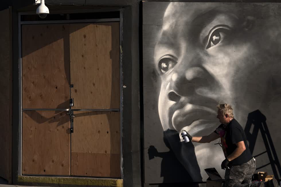 Nghệ sĩ Shane Grammar vẽ bức chân dung của Martin Luther King Jr. trên tấm ván ép bên ngoài một cửa hàng trang sức cao cấp trong bối cảnh lo lắng về các cuộc biểu tình tiềm ẩn và phản ứng bạo lực đối với cuộc tổng tuyển cử vào hôm 2/11 ở Los Angeles. Ảnh AP
